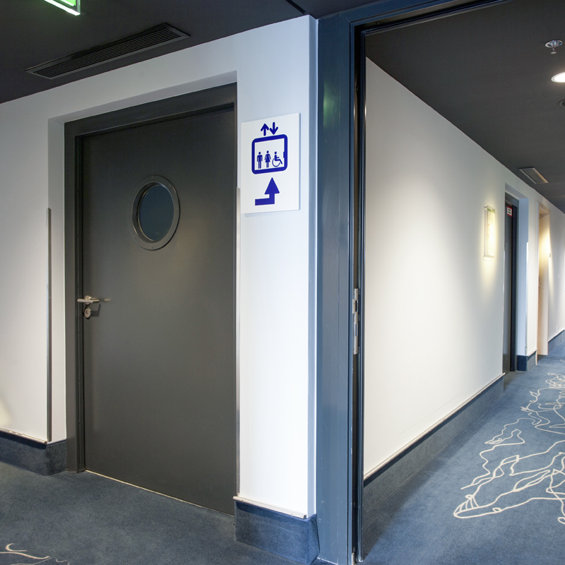 Steel Fire Door with Porthole Window Protecting A Hotel Corridor